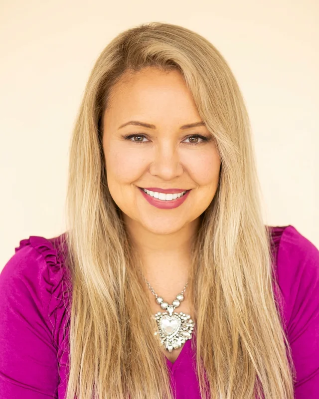 Monique Monroe, Ventura County Realtor, smiling in a magenta blouse